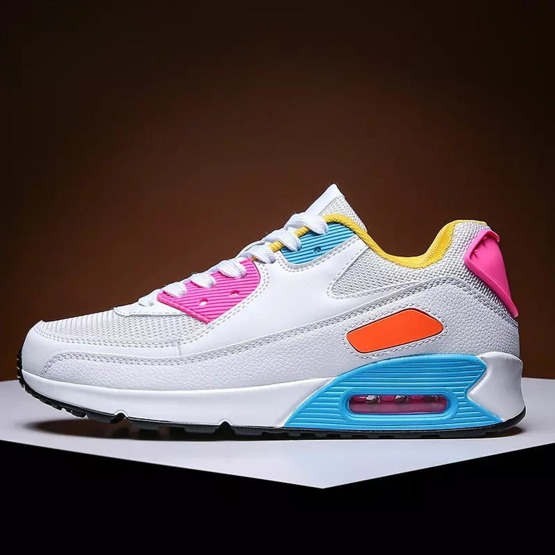 White sneaker with pink, blue, orange, and yellow accents on a black and white surface