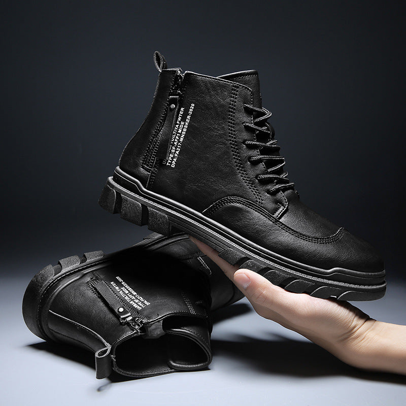 Hand holding black leather combat boots with side zipper and white text print on dark background