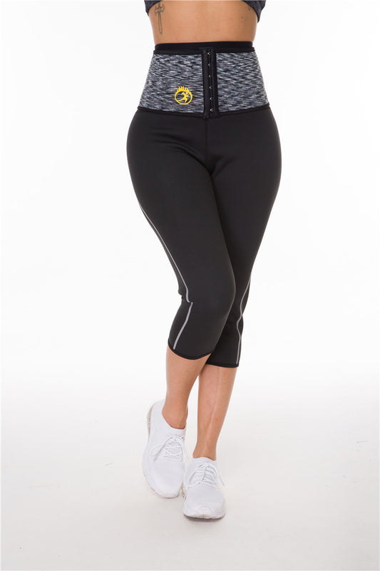 Woman wearing black workout capri leggings, gray waist trainer with yellow logo, and white sneakers