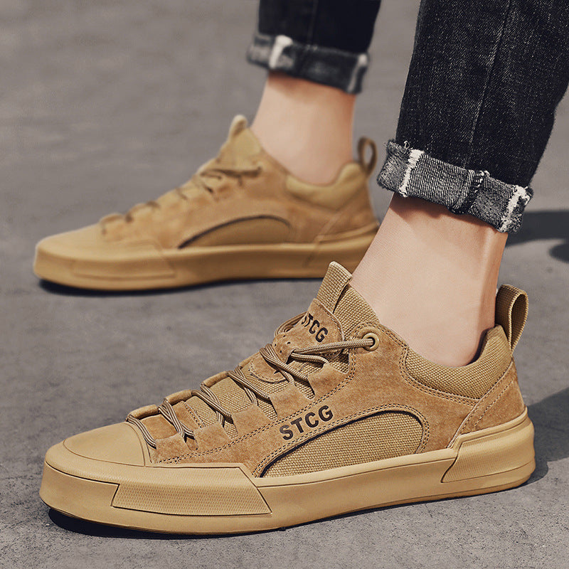 Close-up of tan STCG casual sneakers worn with rolled black jeans on concrete floor