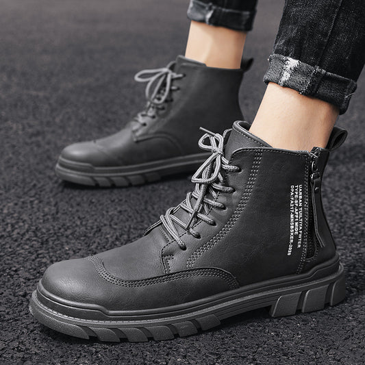 black lace-up men's casual boots with zipper and white text on side, worn with cuffed black jeans on asphalt