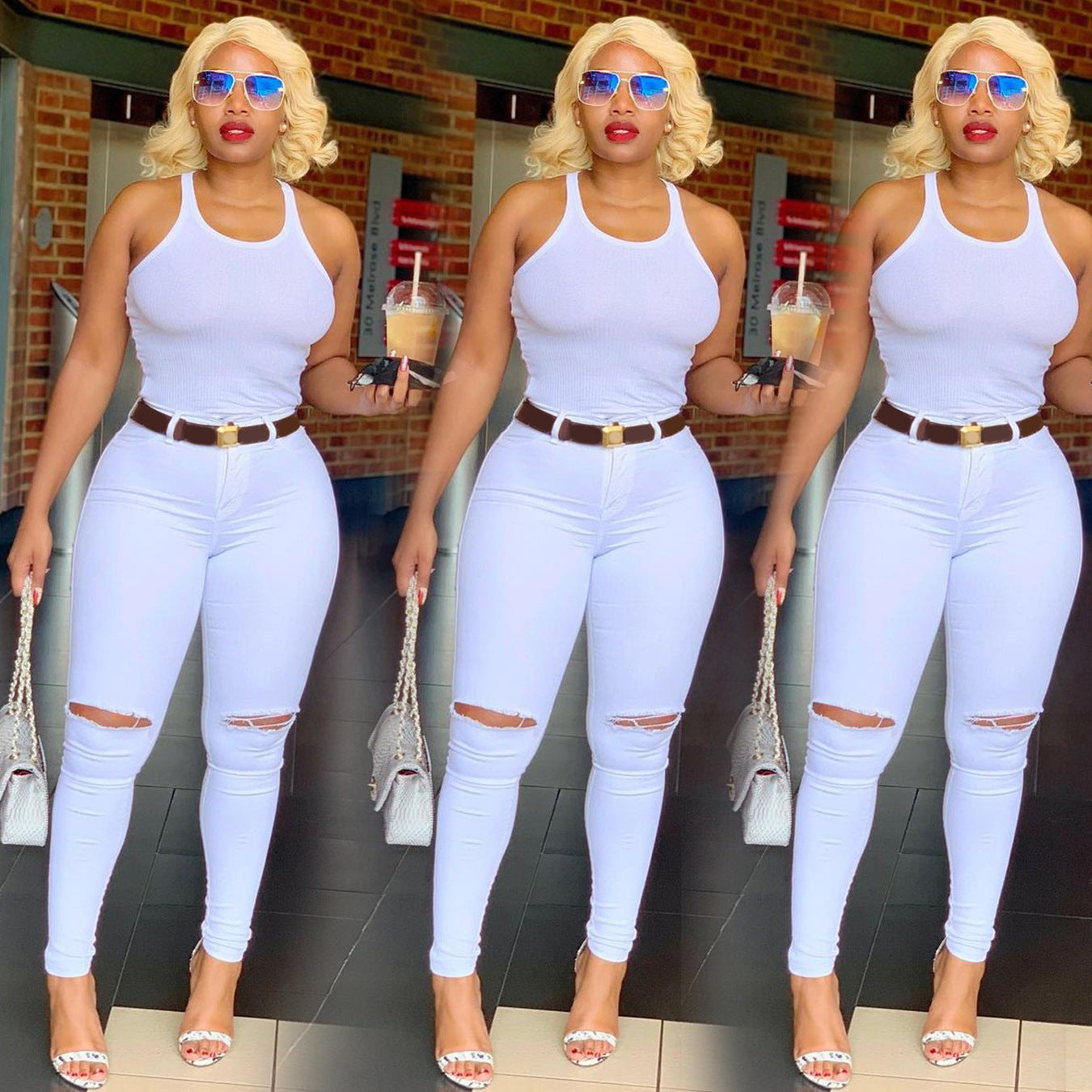 Fashionable woman in white ripped jeans, white tank top, and sunglasses holding iced coffee and handbag