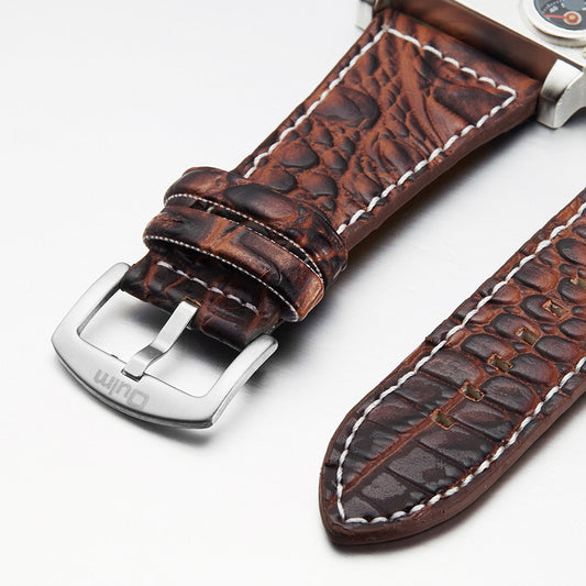 Brown alligator leather watch strap with white stitching and stainless steel buckle on white background