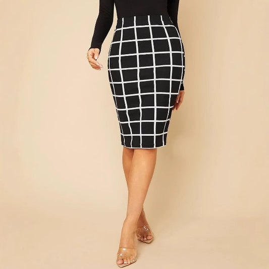 Woman wearing black and white grid pattern pencil skirt with black top and clear heels