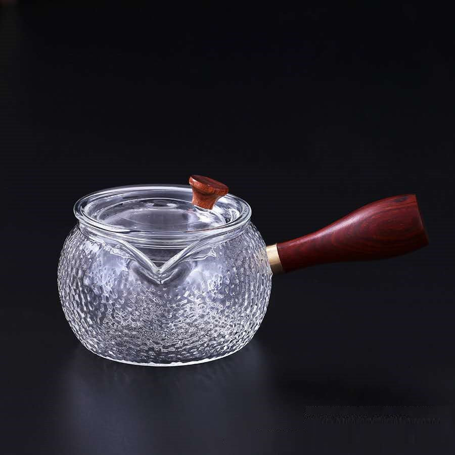Textured glass teapot with wooden handle and lid knob on black background