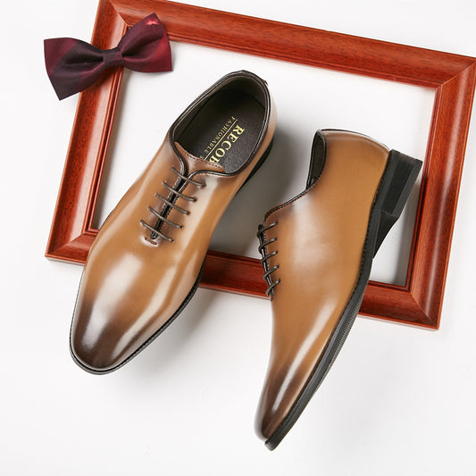 Elegant tan leather men's dress shoes with black laces inside a wooden frame and burgundy bow tie