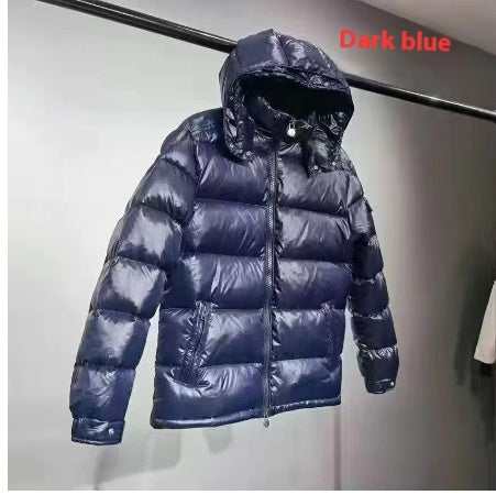 dark blue padded puffer jacket with hood hanging on black rod against gray wall