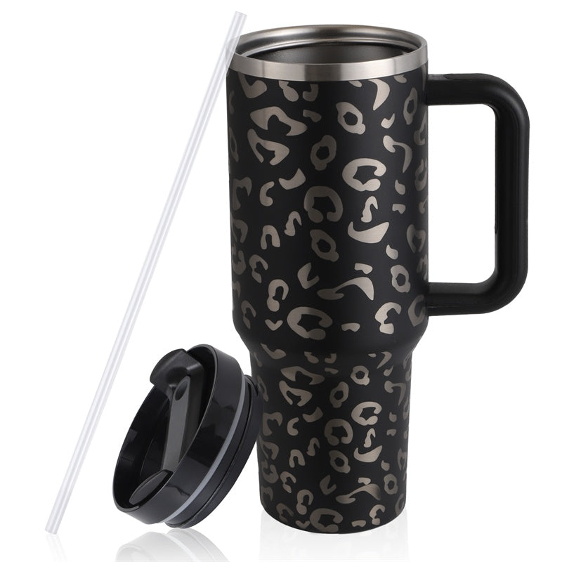 Black travel mug with leopard print, handle, removable lid, and clear straw on white background