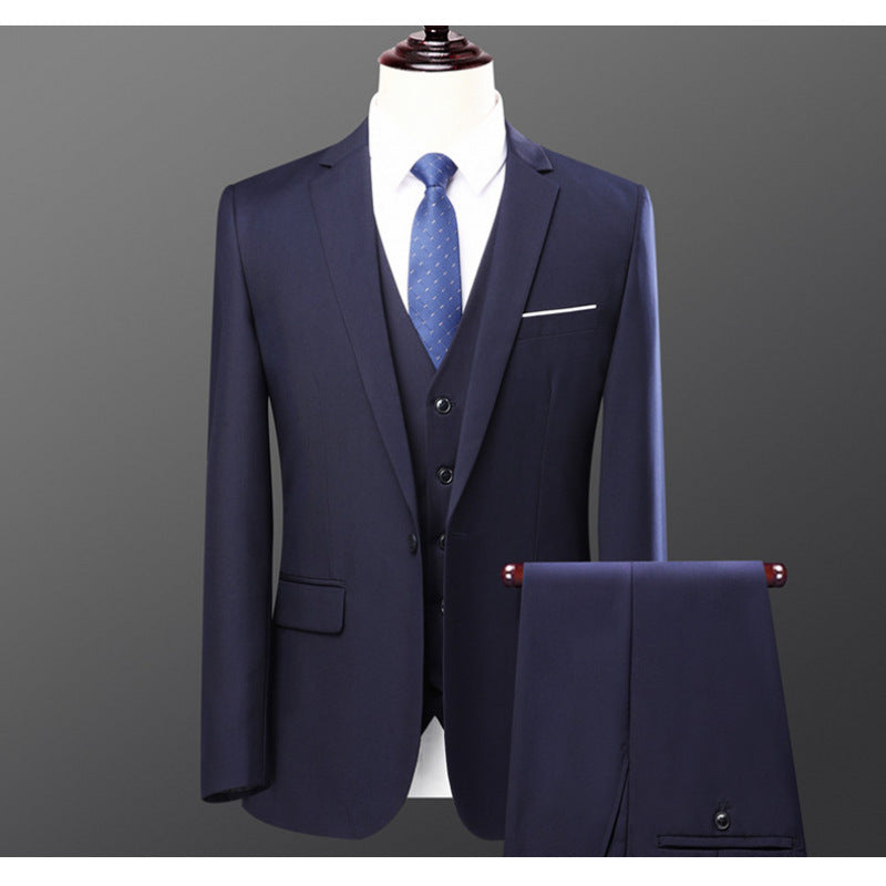 Navy blue three-piece men's suit with matching trousers and patterned blue tie on mannequin
