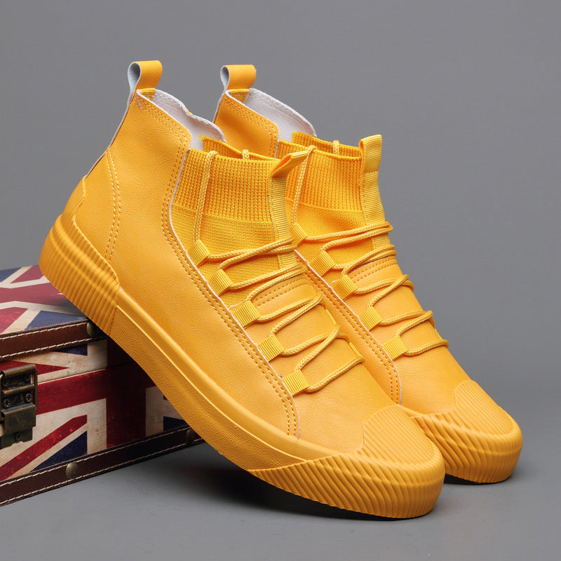 Pair of mustard yellow high-top casual sneakers with knit ankle collar and rubber soles on gray background