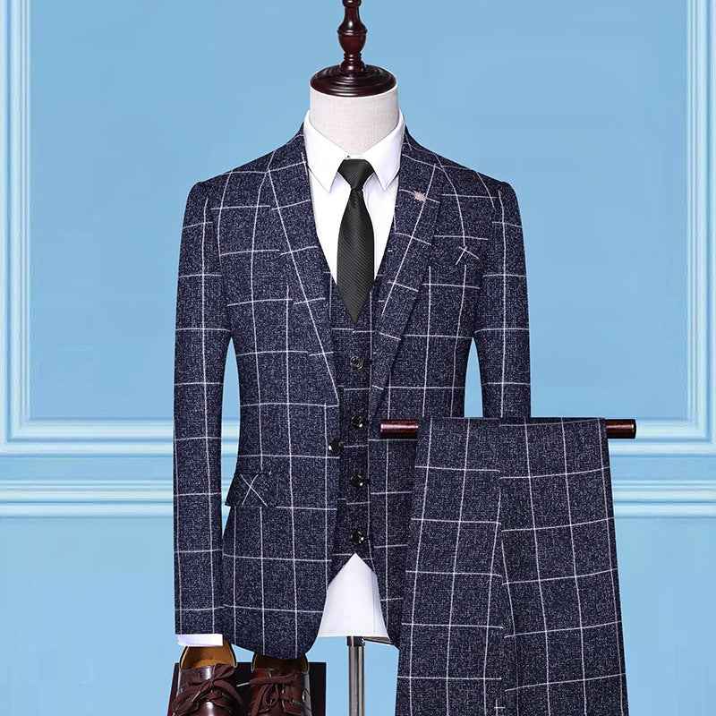 Navy blue checkered three-piece suit with white shirt and black tie on mannequin against blue background
