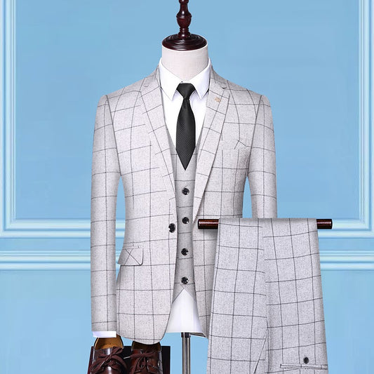 Light gray checkered three-piece suit with black tie on mannequin against blue background