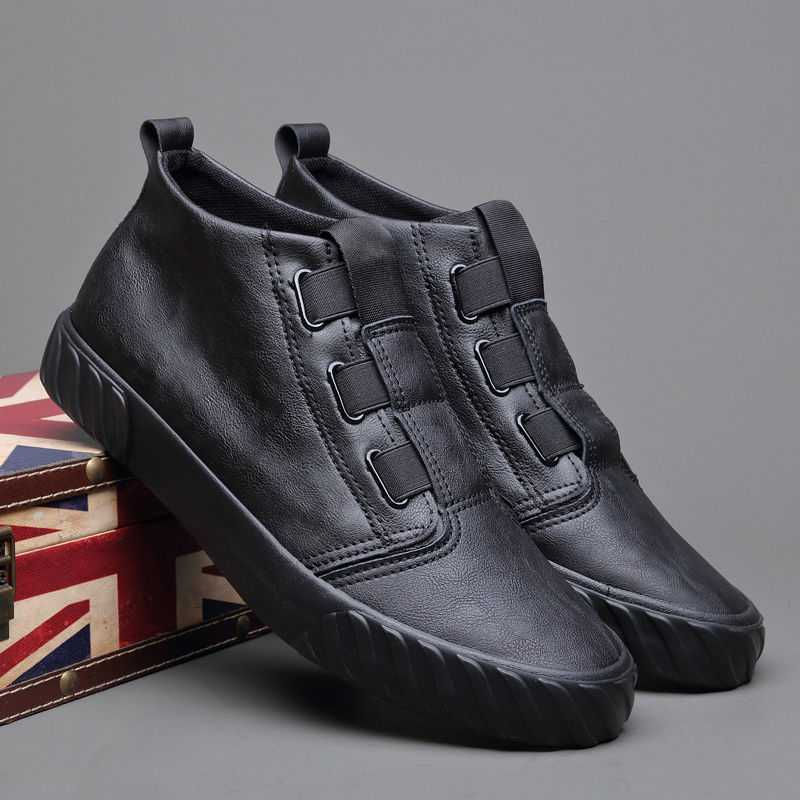 Black slip-on casual shoes with elastic bands and rubber sole on a Union Jack patterned box