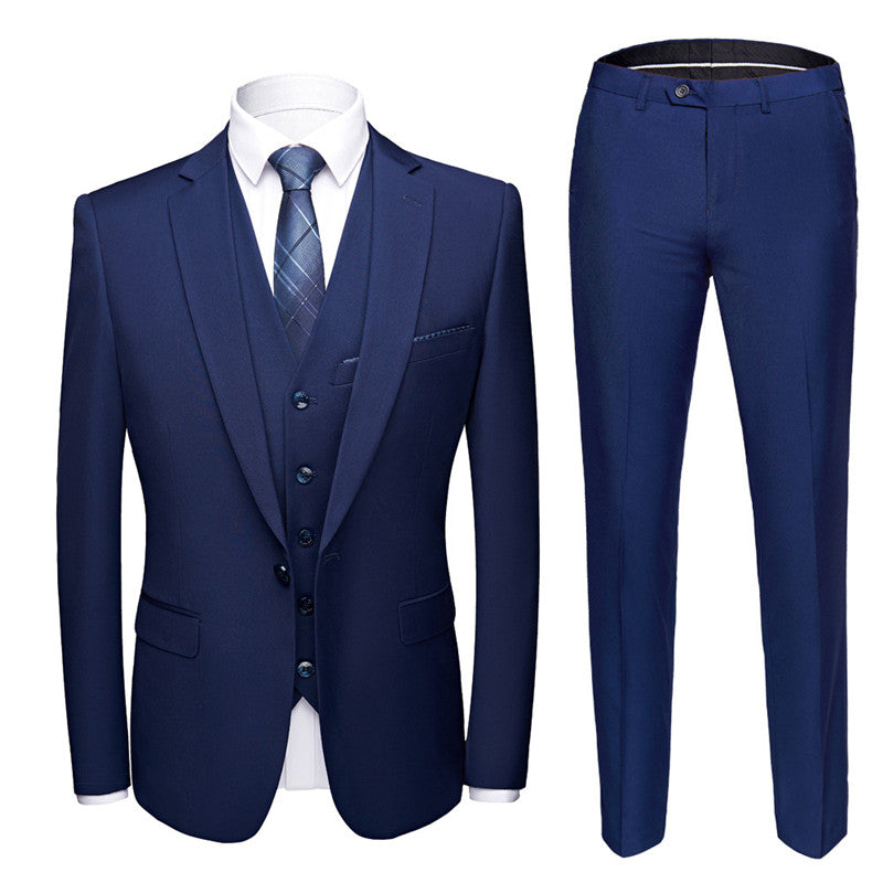 Navy blue three-piece men's suit with blazer, waistcoat, trousers, white shirt, and patterned tie