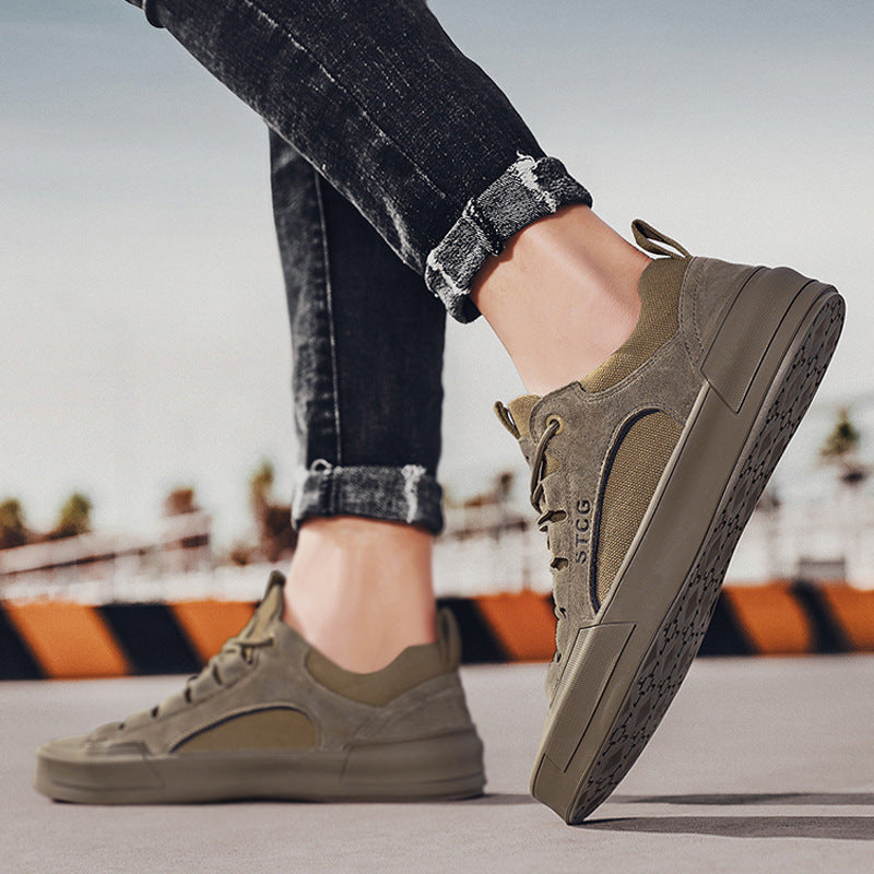 Person wearing olive green casual sneakers with black logo, paired with rolled-up distressed black jeans