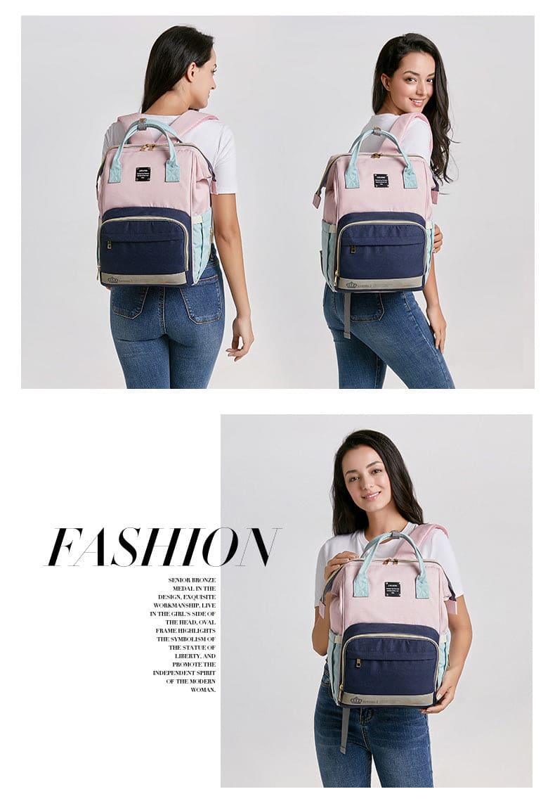 Young woman wearing and holding a stylish pink and navy blue backpack with mint green handles and zippers