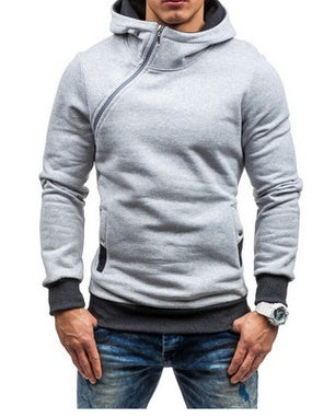 Man wearing light gray asymmetrical zip hoodie with black cuffs and blue jeans