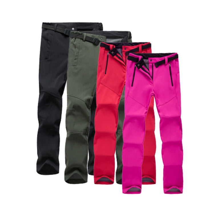 Four pairs of outdoor softshell hiking pants in black, dark green, red, and pink with zippered pockets and adjustable belts