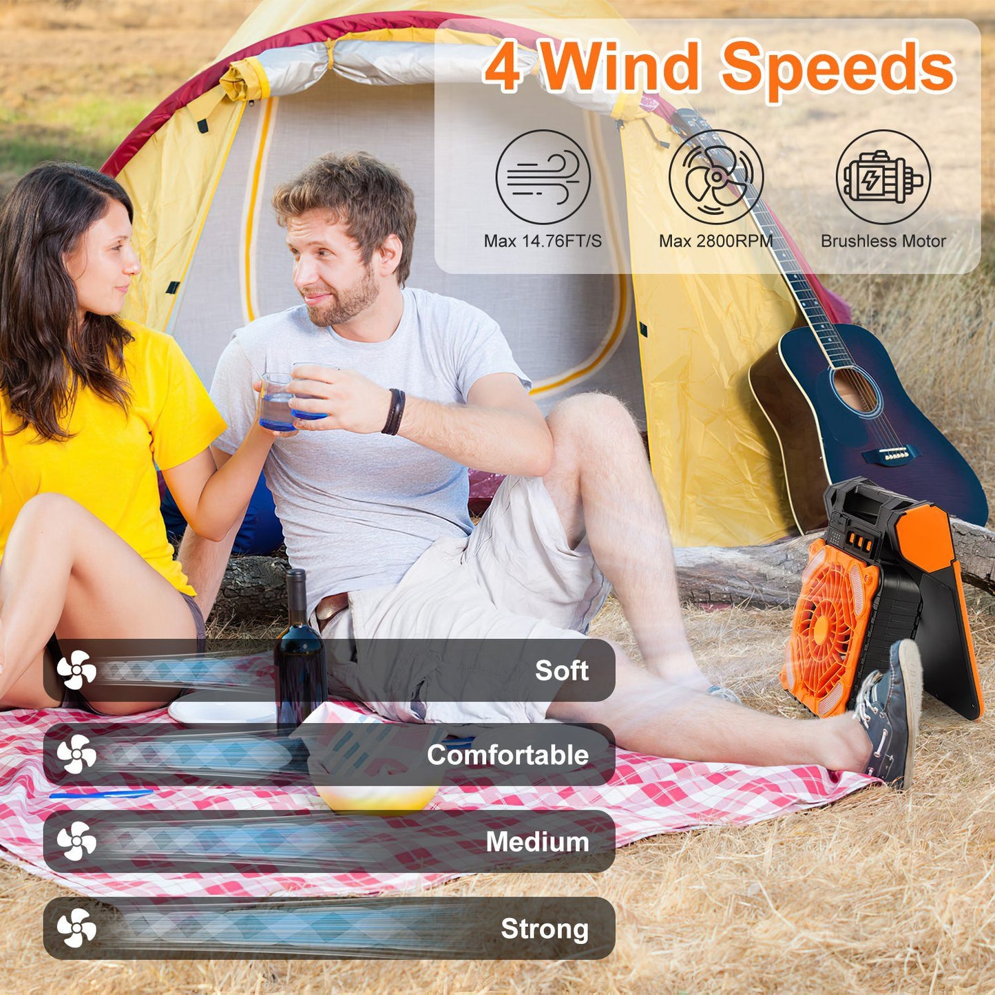 Couple enjoying outdoor picnic near yellow tent with portable orange camping fan showing 4 wind speeds