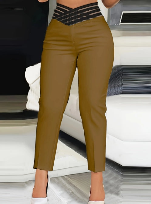 Woman wearing high-waisted brown pants and black mesh top in modern living room setting