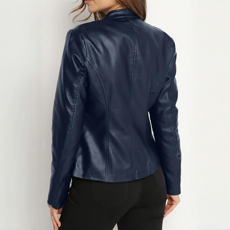 Woman wearing a fitted navy blue faux leather jacket with stitched detailing, back view
