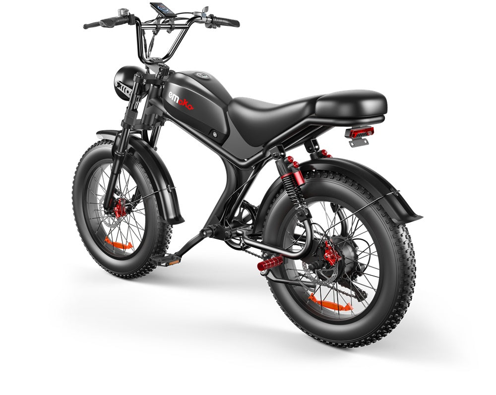 Black Emoka electric fat tire bike with red accents, dual shock absorbers, and rear light on white