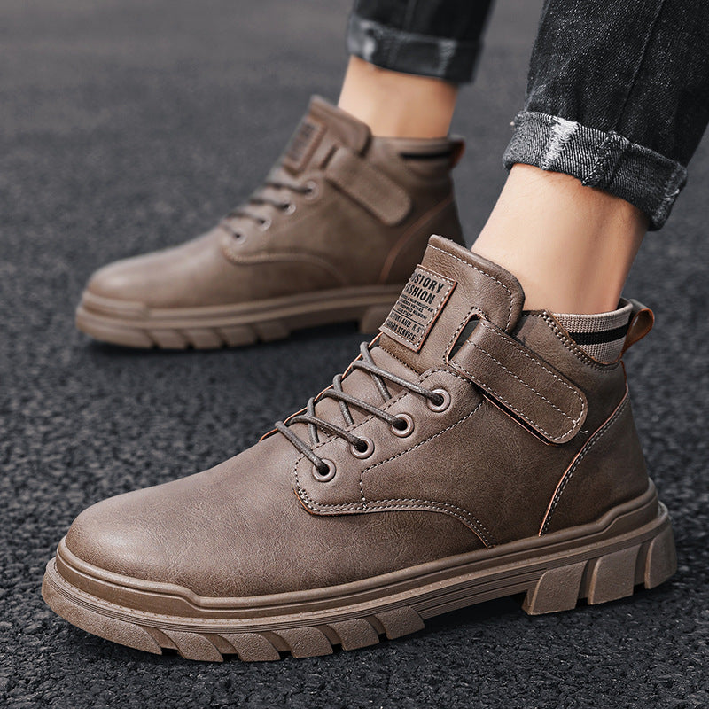 Brown high-top casual men's boots with lace-up and strap on dark asphalt surface