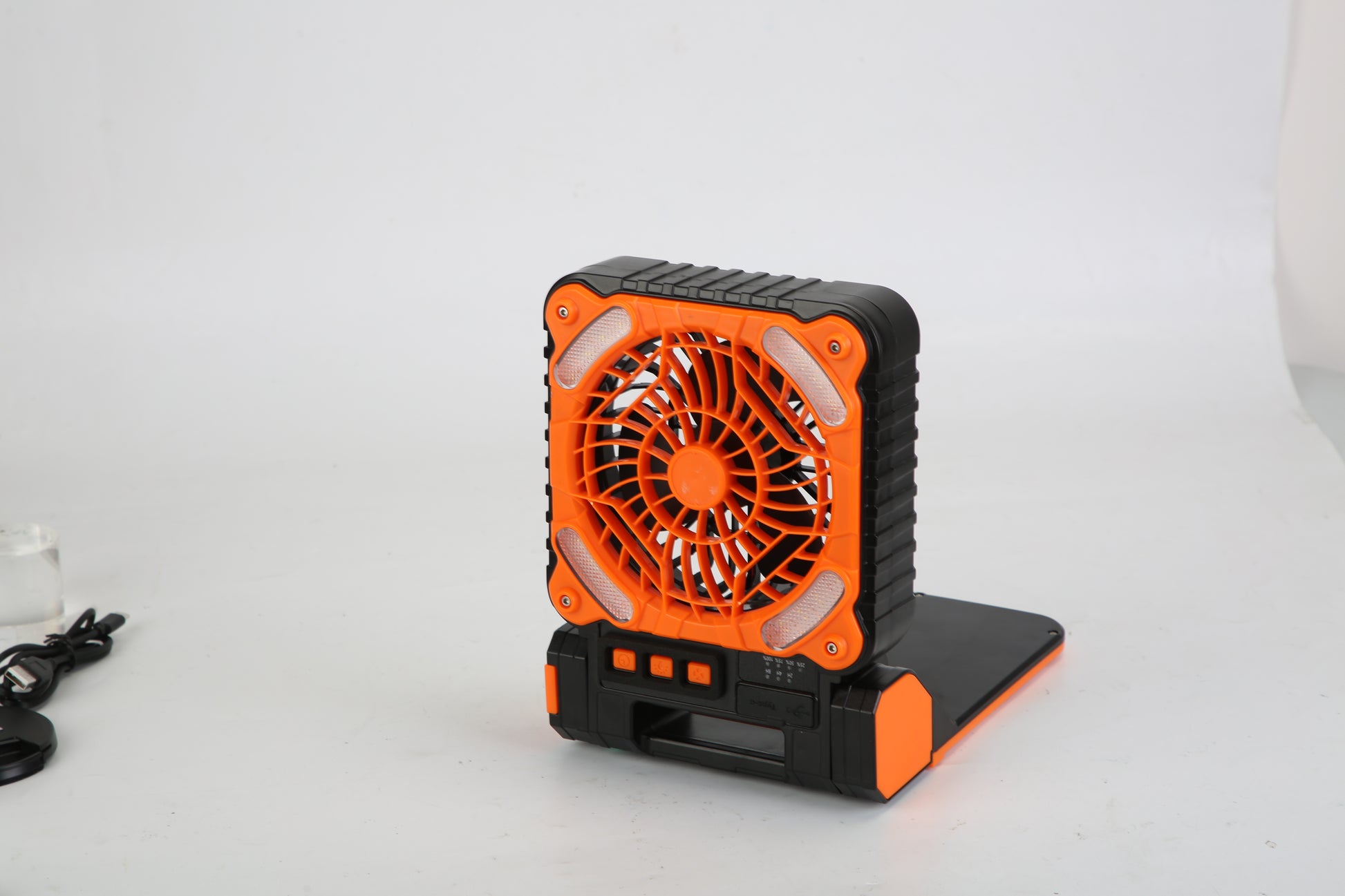 Compact black and orange portable fan with control buttons on white background