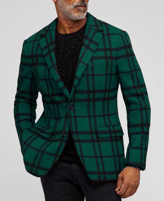 Man wearing green and black checkered blazer with black speckled sweater and black pants