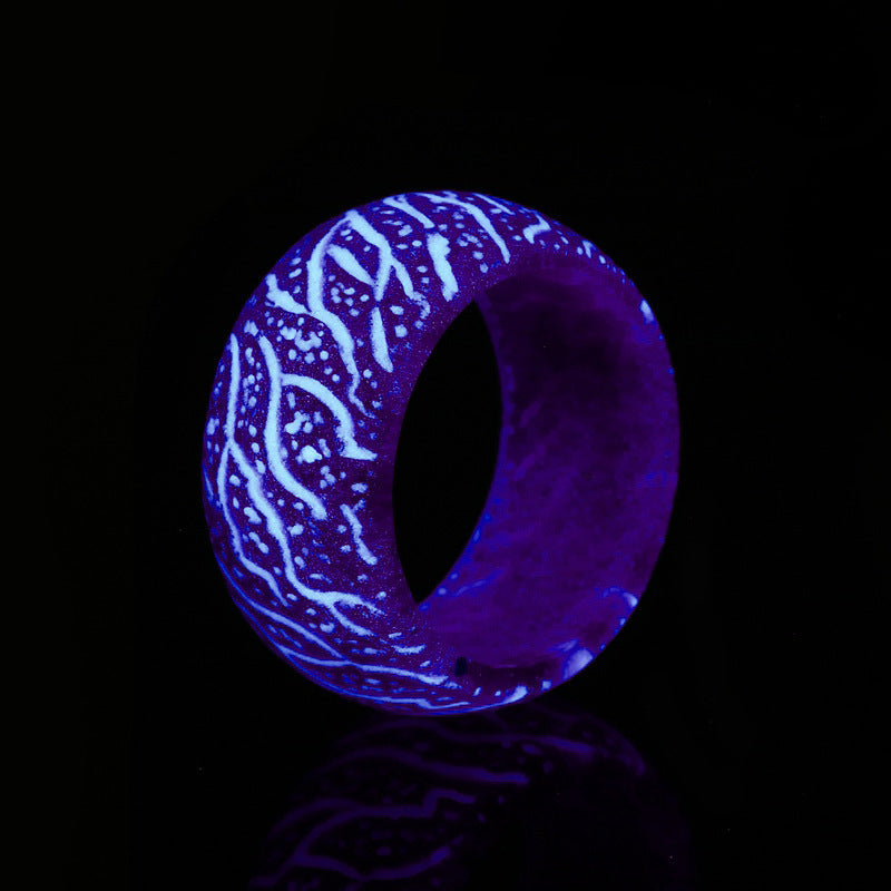 Glowing blue and white patterned ring on black background with neon effect