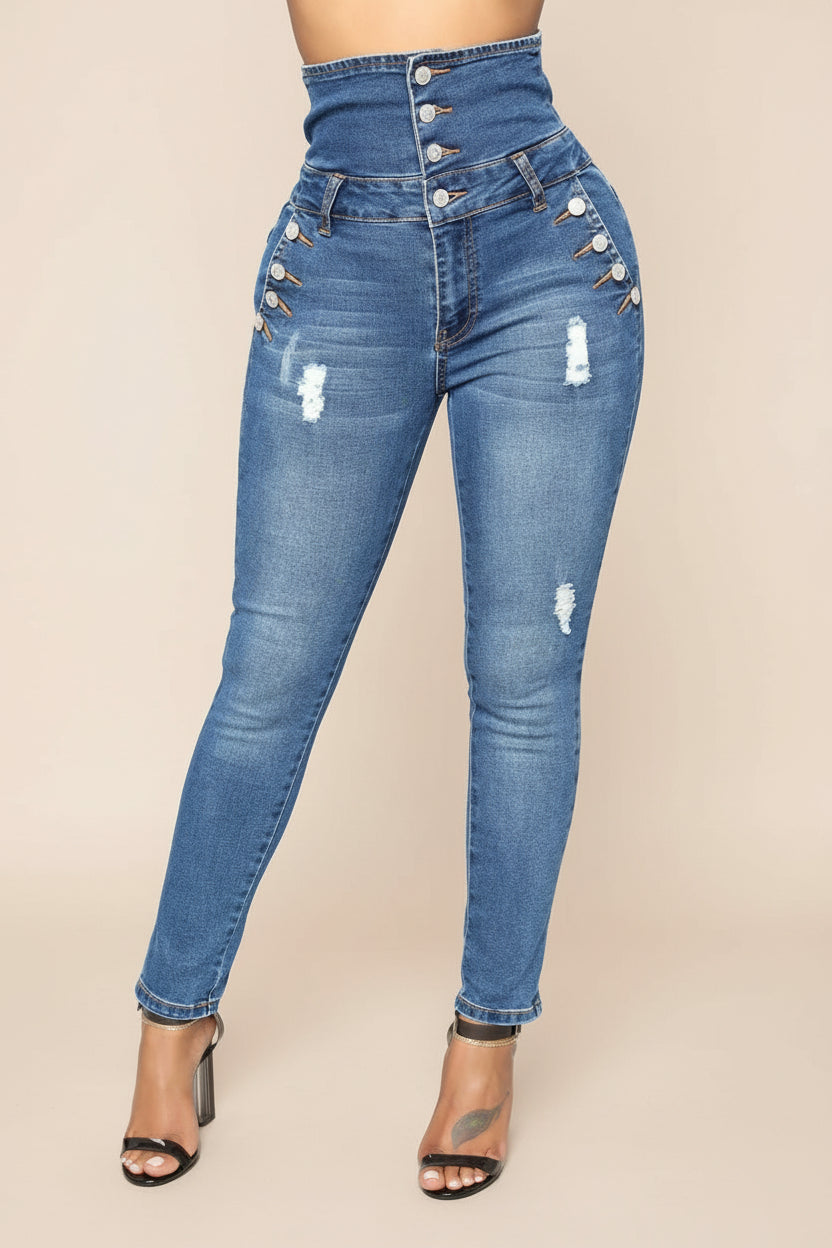 High-waisted skinny blue jeans with button detailing and distressed patches worn with black heels