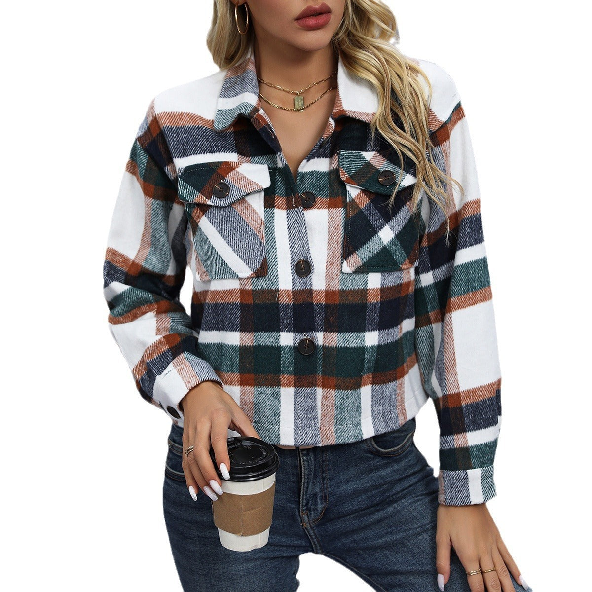 Woman wearing a green, white, and brown plaid button-up shirt holding a coffee cup