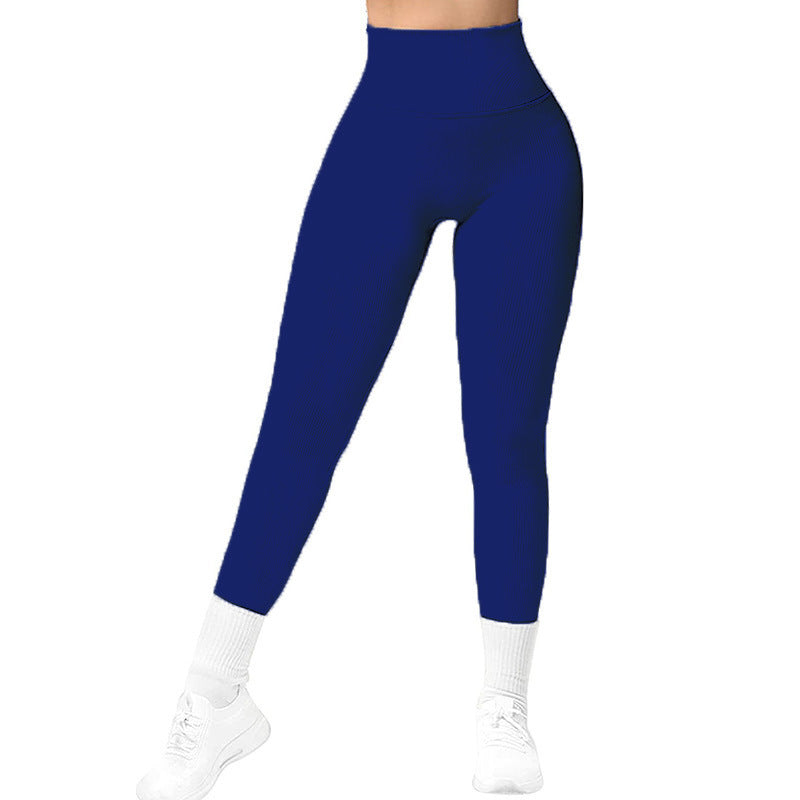 Woman wearing high-waisted navy blue leggings with white socks and white sneakers