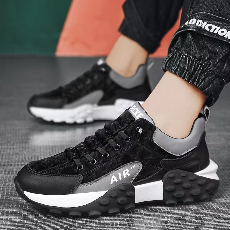 Black and gray athletic sneakers with thick white soles and textured black tread worn with black jogger pants