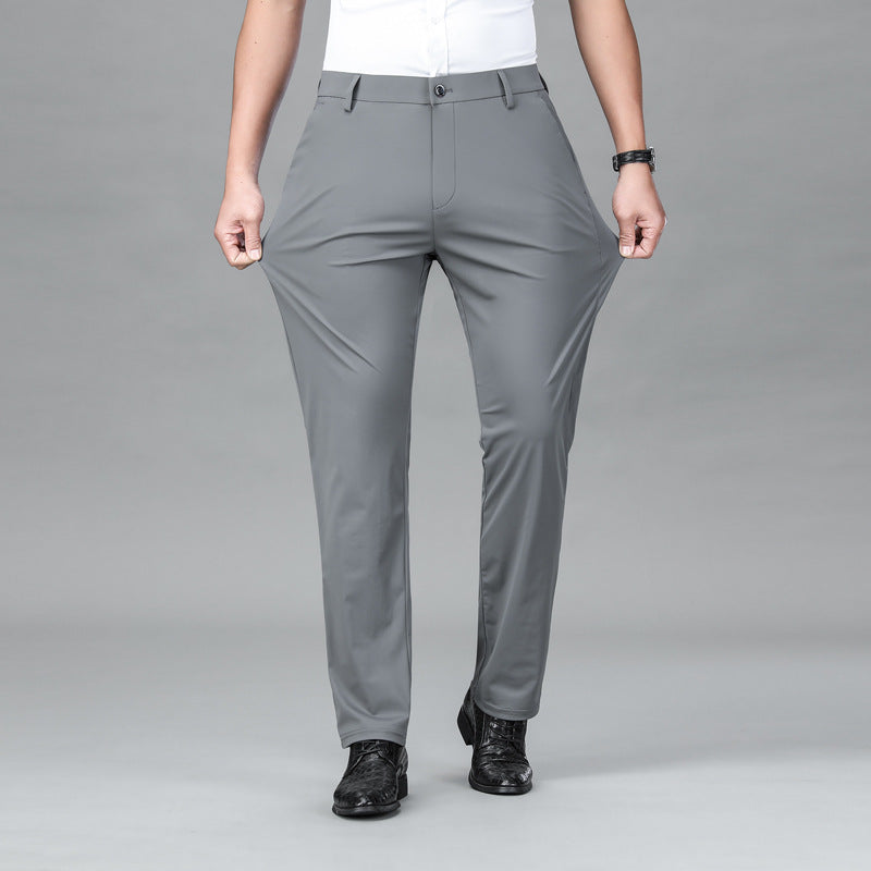 Person wearing gray stretchy pants and black shoes on gray background