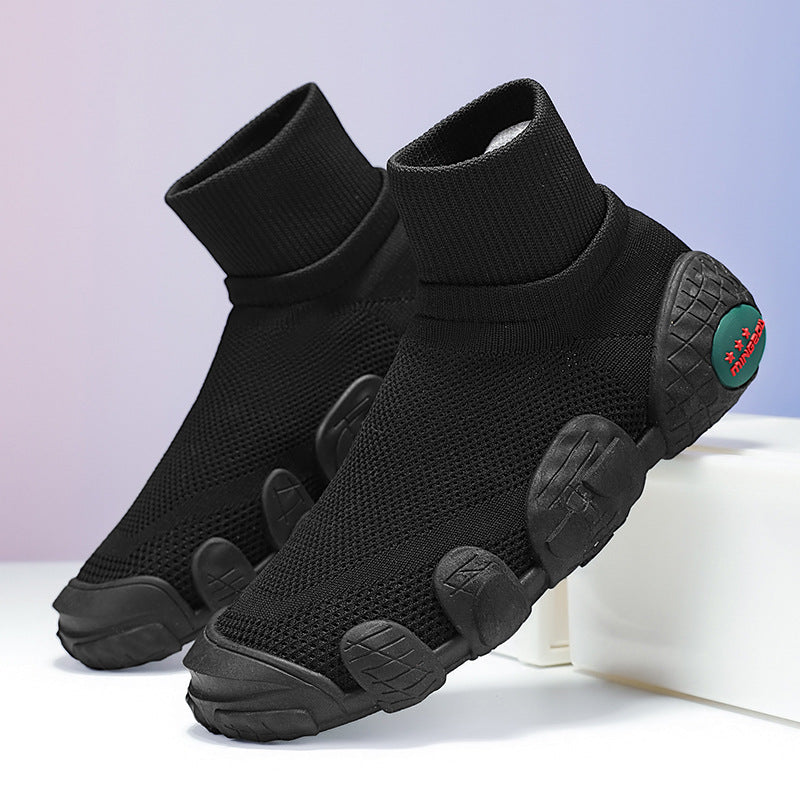 Black sock-style sneakers with mesh upper and unique segmented rubber sole on light background