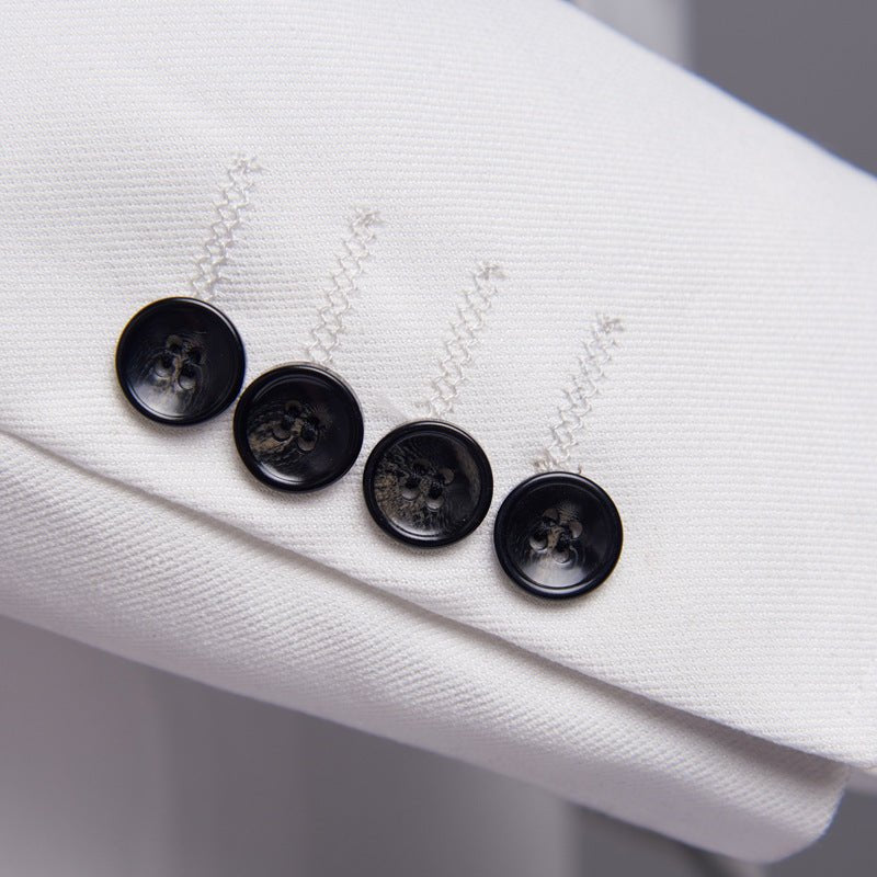 Close-up of black buttons on white men's suit cuff, formal wedding suit detail
