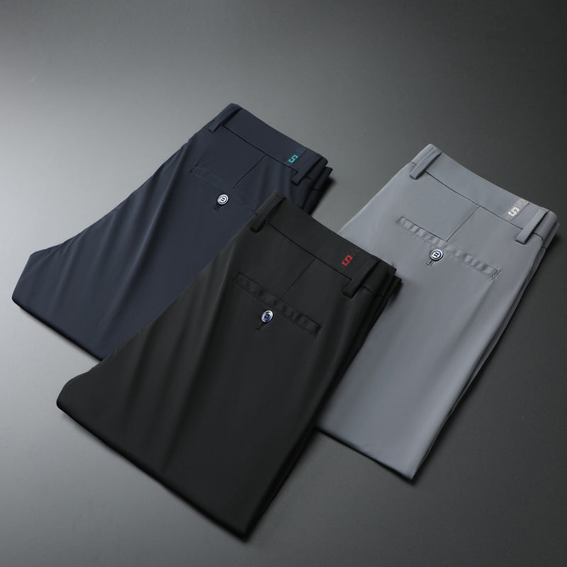 Three pairs of neatly folded men's dress pants in navy, black, and gray with buttoned back pockets