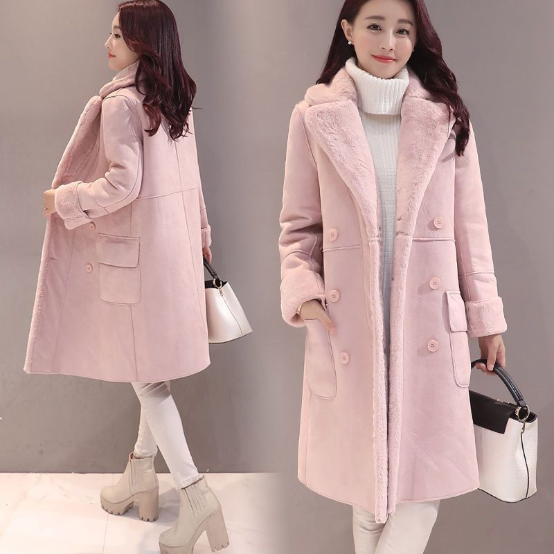 Woman wearing stylish pink double-breasted wool coat with fur collar and cuffs, white turtleneck and boots