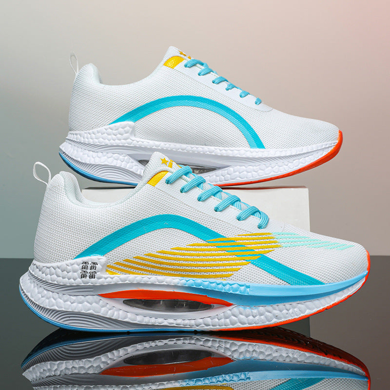 White athletic sneakers with blue and yellow accents, textured soles, and orange outsoles on reflective surface
