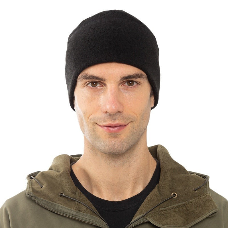 Man wearing black fleece beanie and olive green jacket on white background