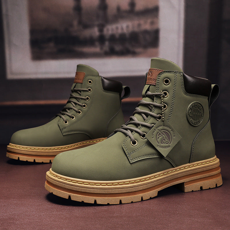 Pair of olive green leather boots with brown padded collars and rugged tan soles on dark surface