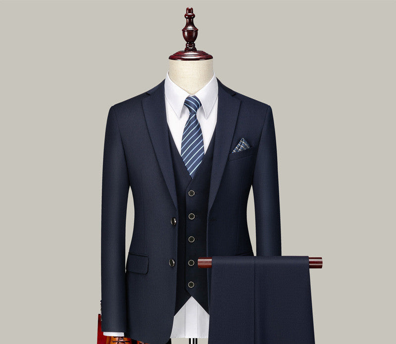 Navy blue three-piece men's suit with striped tie and pocket square on mannequin