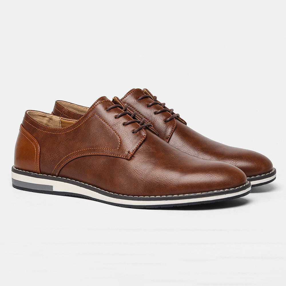 Pair of brown leather casual lace-up shoes with white and black sole on white background