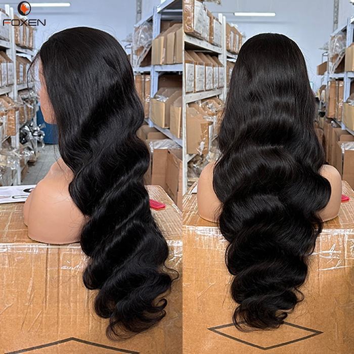 Long wavy black hair wig displayed on mannequin heads in a warehouse with cardboard boxes