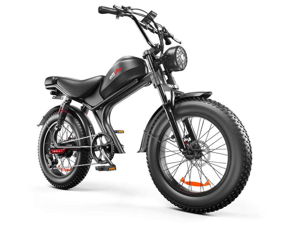 Black Emoka electric fat tire bike with front headlight, rear shock absorbers, and thick knobby tires on white background