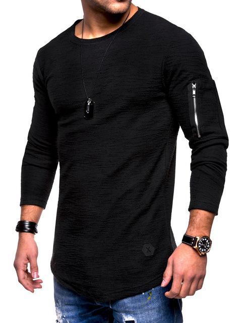 man wearing black long-sleeve textured shirt with zip pocket on sleeve, blue ripped jeans, black watch and bracelet
