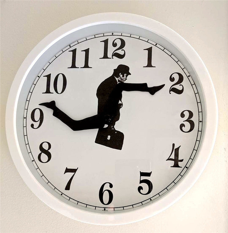 White wall clock with black numbers showing a man in a suit as the clock hands, mid-kick pose