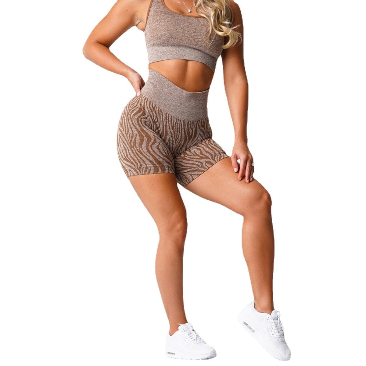 Woman wearing brown seamless zebra print high-waisted shorts and matching crop top with white sneakers