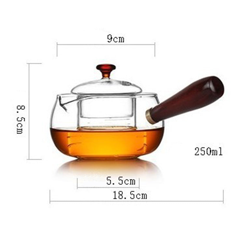 Glass teapot with wooden handle and lid, filled with amber tea, dimensions marked